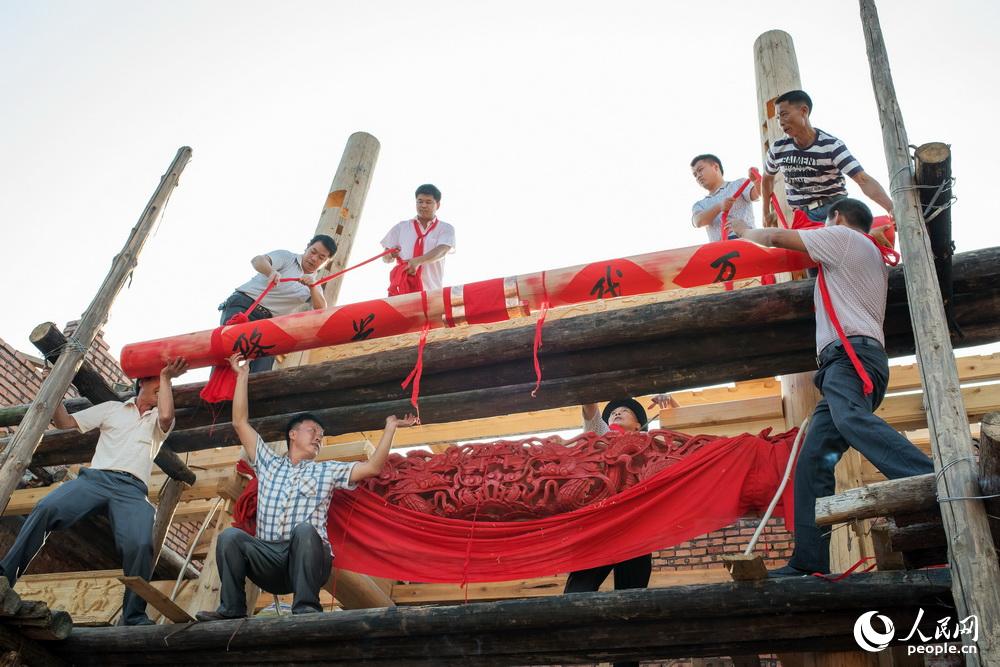 “上梁”是农村建房最重要的环节，它宣布了新居即将大功告成。体现出人们对幸福生活的不断追求。朱孝荣2017年8月21日拍摄于湖南省汝城县。