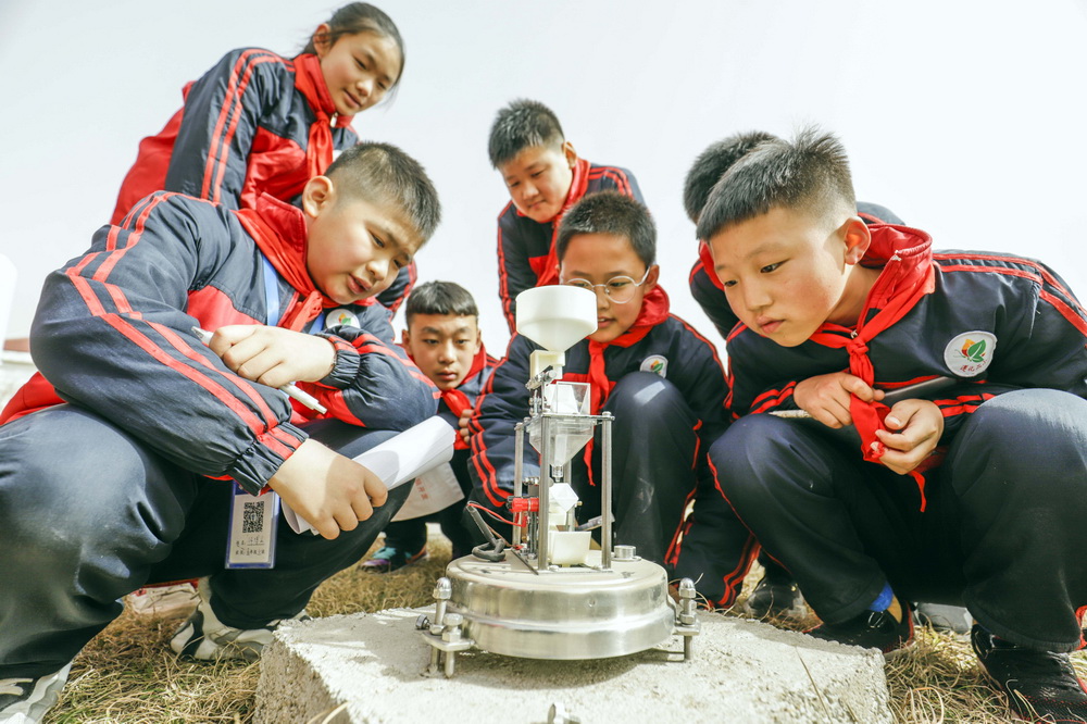 3月22日，在河北省遵化市气象局监测场，小学生了解气象监测设备。新华社发（刘满仓 摄）