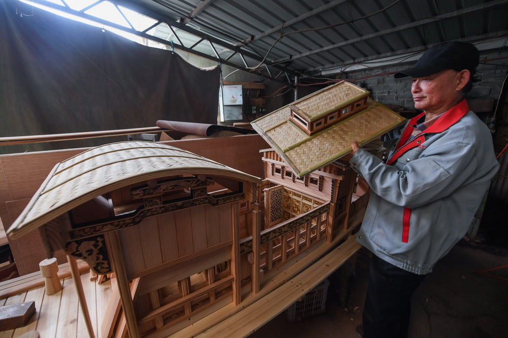 4月13日，在位于嘉兴市南湖区余新镇的嘉兴市鸣华船模制作有限公司车间内，67岁的韩鸣华一丝不苟地检查工人手工制作的红船模型。
