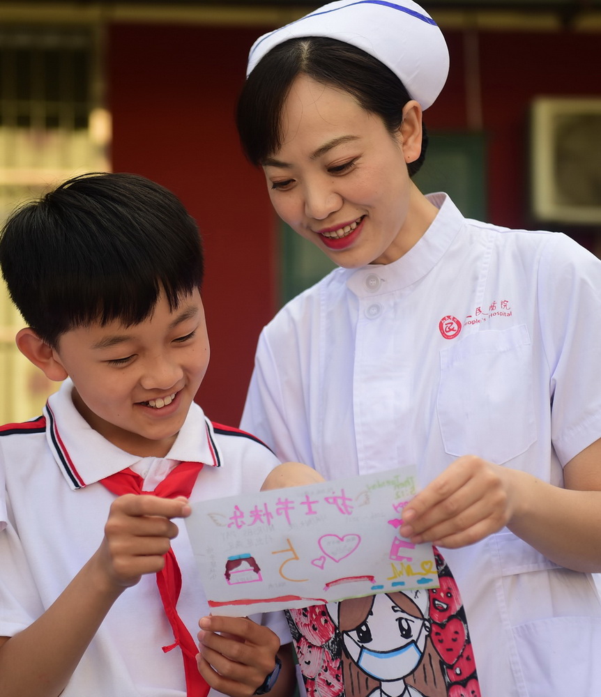 5月11日，河北省沧州市新华区车站小学学生为沧州市人民医院的护士阿姨送上美术作品，表达敬意。新华社发（傅新春 摄）