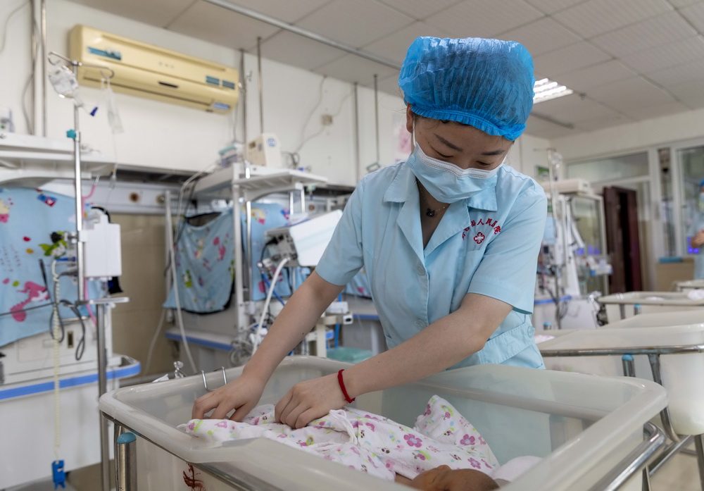 5月11日，护士在贵州省黔西市人民医院新生儿科为患儿做晨间护理。新华社发（翟培声摄）