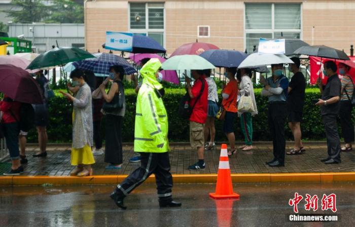 资料图：去年7月9日，北京中关村中学考点外，家长在雨中等待考生出考场。 <a target='_blank' href='http://www.chinanews.com/'><p class=