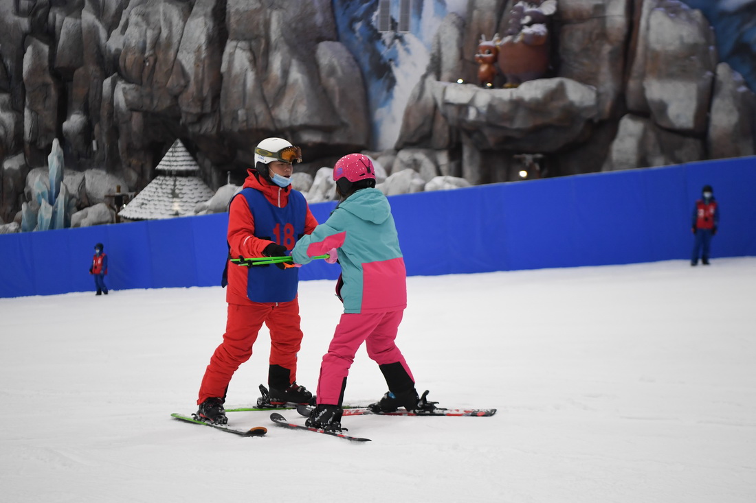 游客（右）在湘江欢乐城内学习滑雪（2020年7月11日摄）。湘江欢乐城所在地原是一座巨大的废弃矿坑，历经6年建设，建成总面积约3万平方米的大型室内滑雪场。新华社记者 薛宇舸 摄