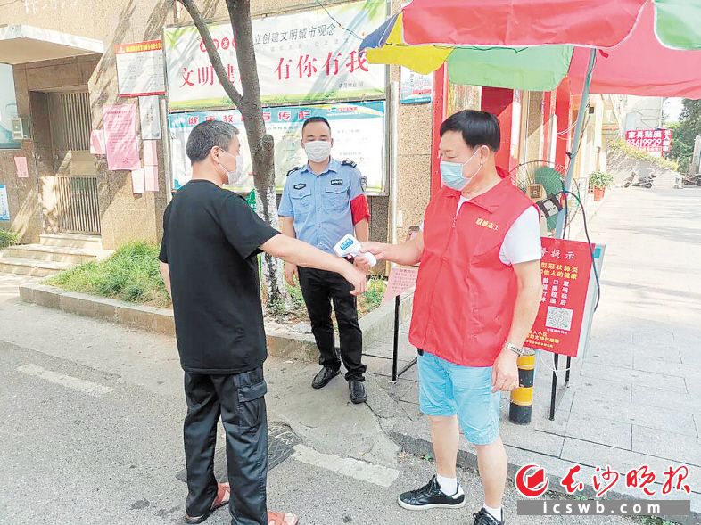 　　浏阳香山国际小区，老党员钟杨华为进门居民测量体温。 　　受访者供图