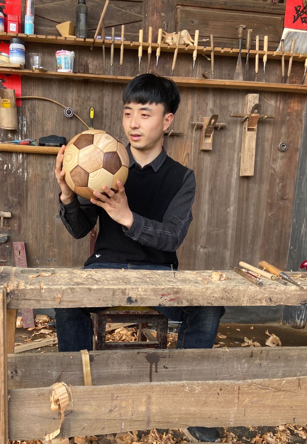 安旭展示他用木头做的足球。（采访对象供图）.jpg