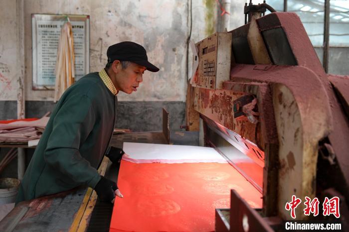 宣纸厂工人在裁剪春联纸。　张娅子 摄