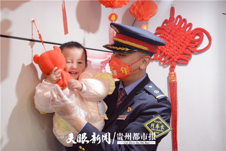 列车长刘蓄抱着小旅客摘虎年小福娃。.jpg