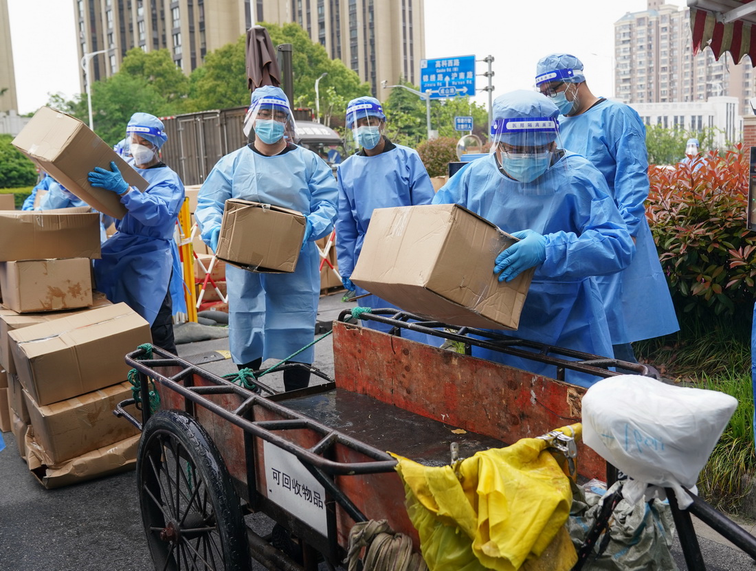 在上海市浦东新区北蔡镇一处居民区，工作人员将消杀完的物资装运上三轮车，准备配送给小区居民（4月19日摄）。