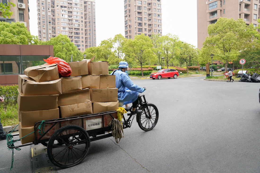 在上海市浦东新区北蔡镇一处居民区，工作人员将消杀完的物资转运至居民楼（4月19日摄）。