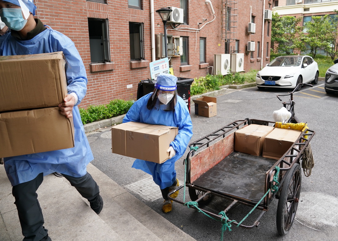 在上海市浦东新区北蔡镇一处居民区，工作人员卸下物资，准备配送给小区居民（4月19日摄）。