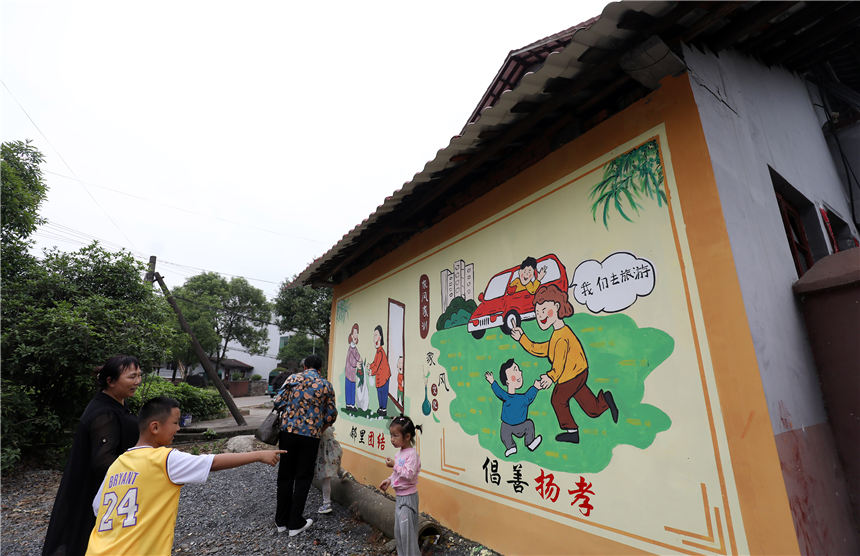 村民、小朋友在欣赏墙体绘画。李铁南摄