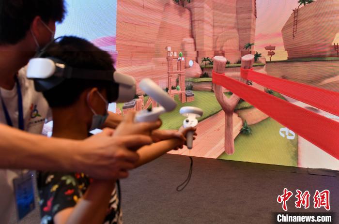 图为小朋友体验VR游戏。　吕明 摄