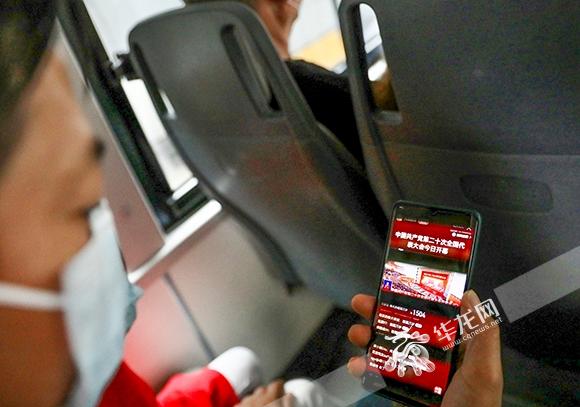 市民在公交车上使用手机收看中国共产党第二十次全国代表大会开幕会直播。华龙网-新重庆客户端记者 李裕锟 摄
