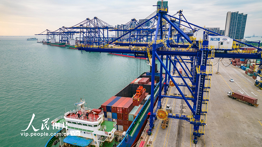 海口港集装箱码头一派繁忙景象，停泊码头的集装箱货轮正在进行装货卸货。