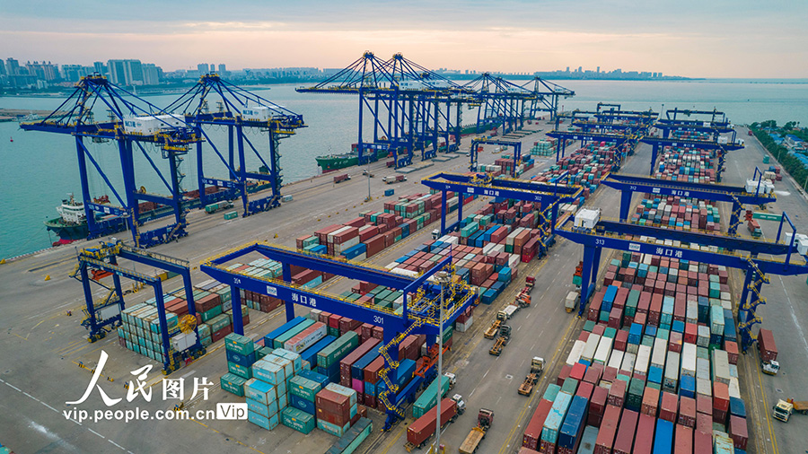 海口港集装箱码头一派繁忙景象，停泊码头的集装箱货轮正在进行装货卸货。