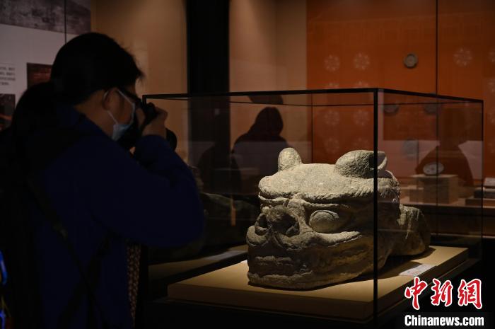 渤海国上京龙泉府遗址宫城正门出土的石螭首吸引参观者拍照。　陈楚红 摄