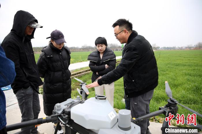 农业植保无人机培训人员(右一)讲解使用规范及注意事项。　胡扬辉 摄
