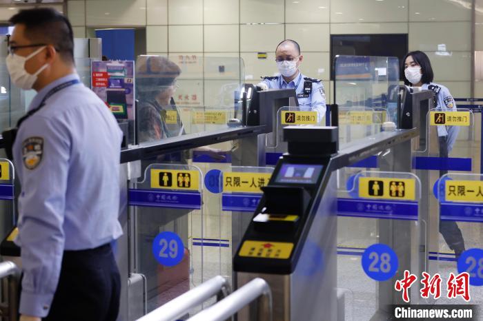 在浦东机场T2航站楼内，边检民警在快捷通道处进行人员信息抽查。　殷立勤 摄
