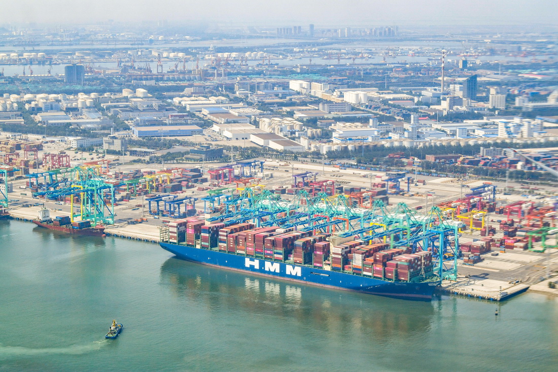 这是6月16日从直升机上拍摄的一艘停靠在天津港北疆港区C段智能化集装箱码头的集装箱货轮。