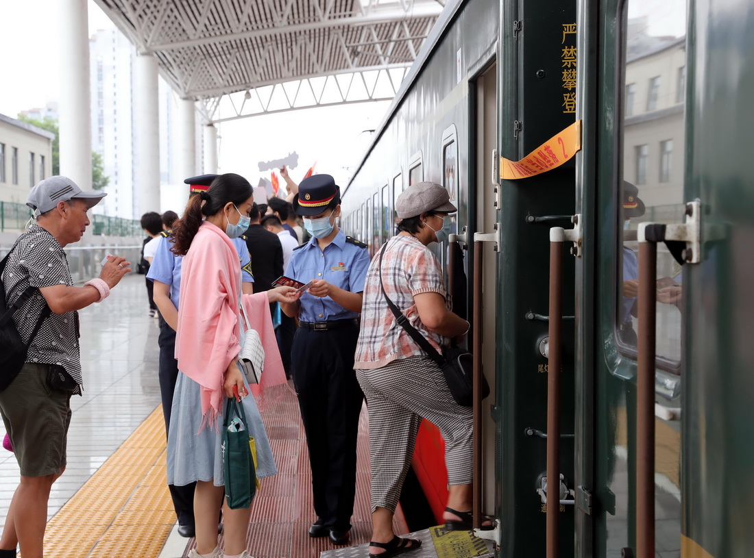 6月30日，铁路上海客运段列车员顾书闻在车门口验票。新华社记者 王翔 摄