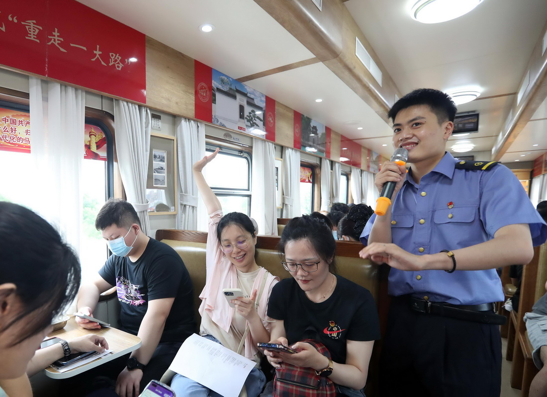 6月30日，上铁国旅讲解员彭晓磊组织旅客参与党史专题知识互动竞答。新华社记者 王翔 摄