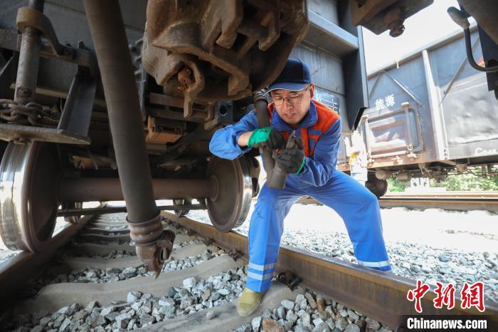 7月3日，朔黄铁路黄骅港站连结员对C64车体进行组合作业。　孟鑫 摄