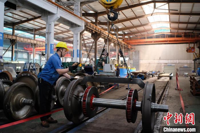 图为一名工人正在吊装检修铁道车辆轮对。　刘俊聪 摄