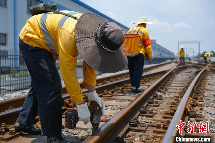 重庆西线路车间梨树湾检查工区工人们正在进行联结零件紧固作业。　何蓬磊 摄