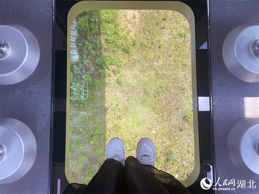 空轨的玻璃底面，乘客站在上面仿佛在空中漂浮前进。人民网记者 周恬摄
