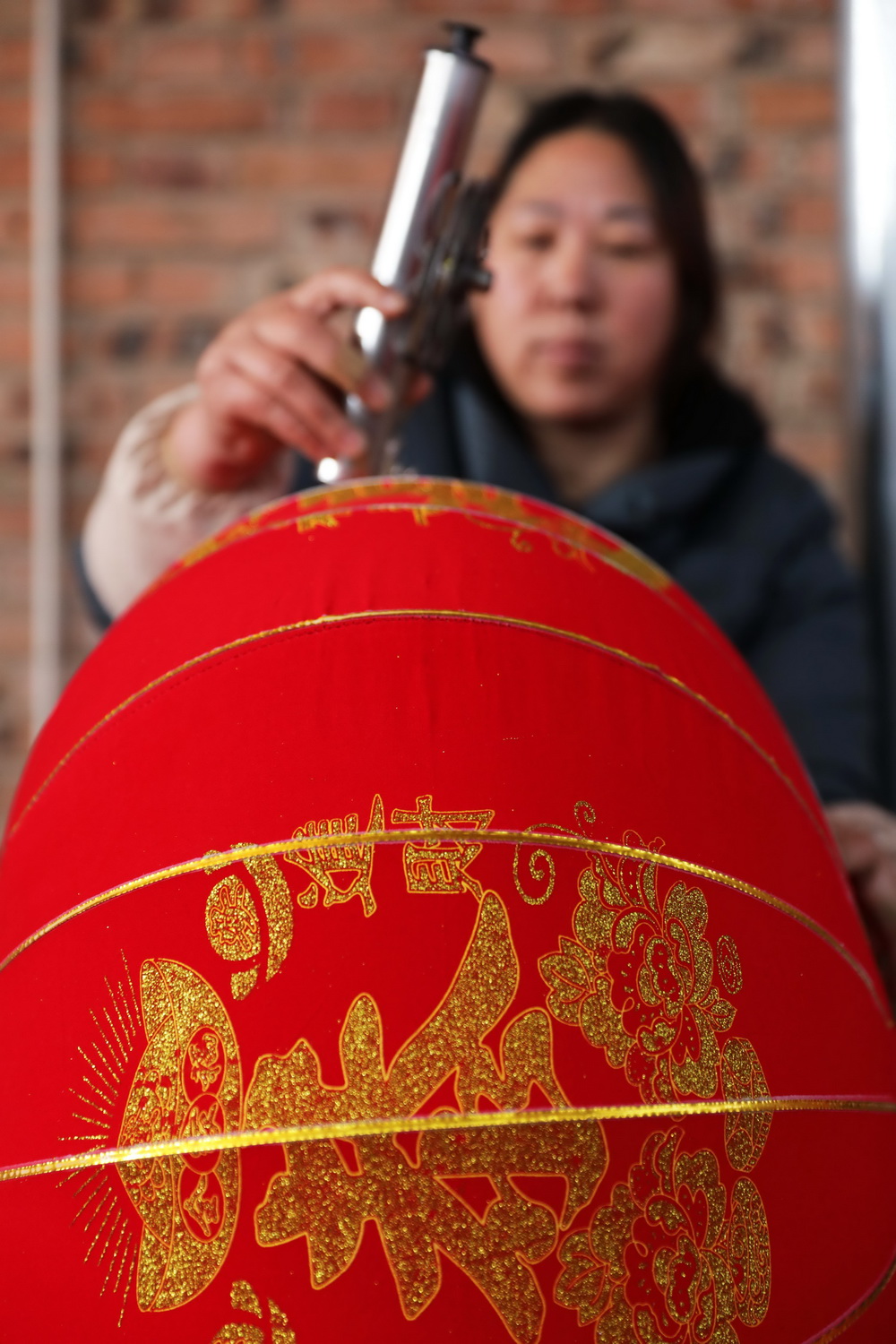12月21日，在河南省武陟县西陶镇石荆村一家灯笼加工厂，工人在制作大红灯笼。