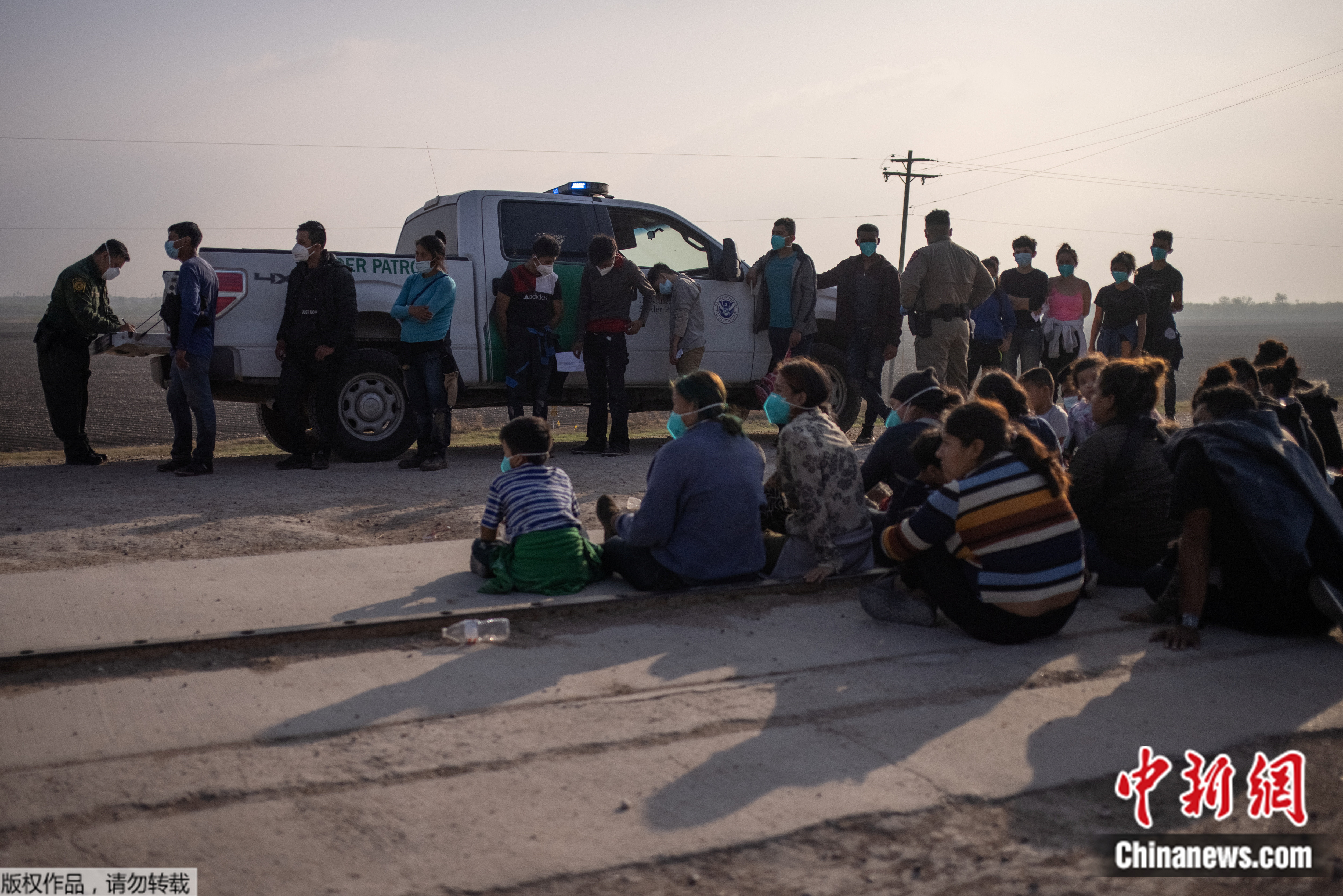 图1：当地时间3月17日，美国得克萨斯州，边境执法人员与前来寻求庇护的非法移民家庭。