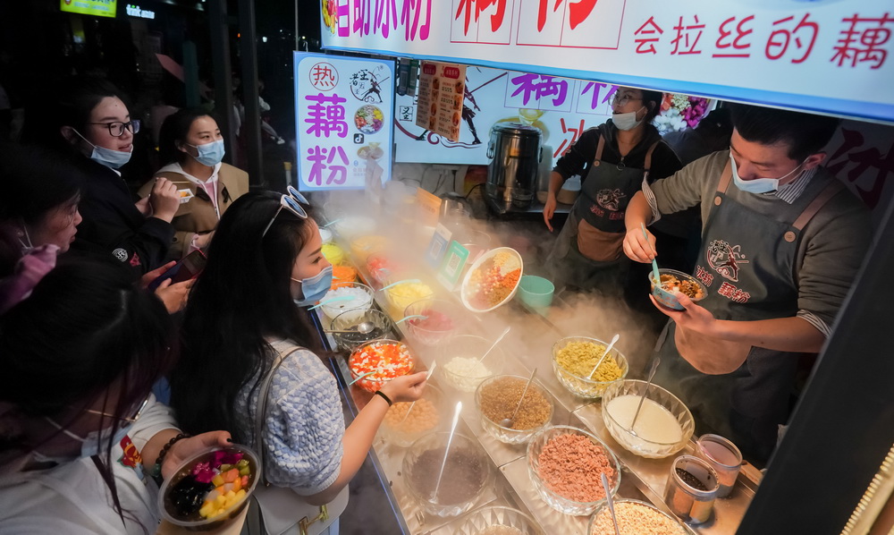 人们在武汉市著名的小吃街户部巷休闲消费（3月28日摄）。新华社记者 程敏 摄