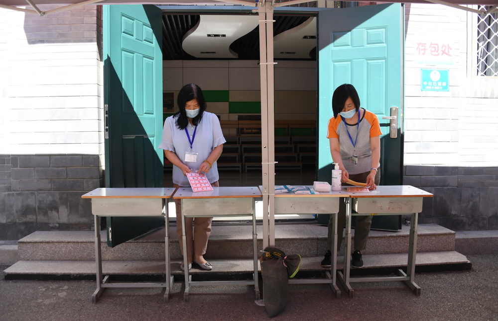 6月5日，在北京实验学校（海淀）考点，工作人员在考生存包处做准备工作。