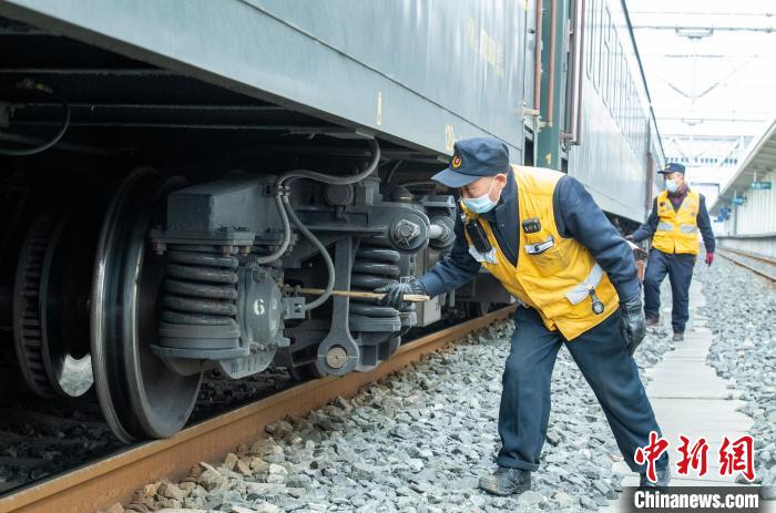 检车员巫仕文正在检查列车走行装置。