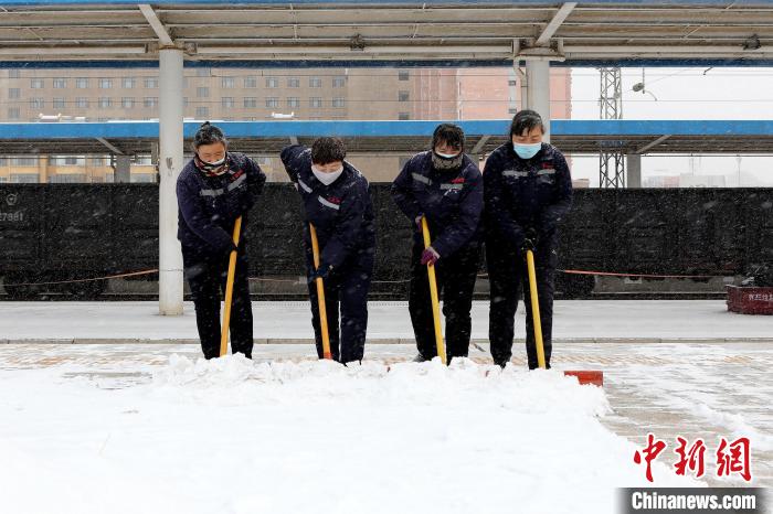 图为工作人员清理火车站台积雪。　高志瑛 摄