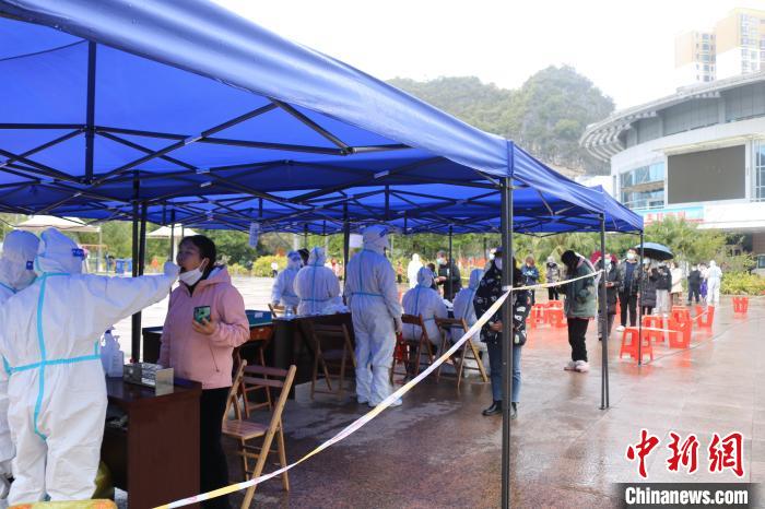 2月8日，德保县民众雨中排队接受核酸检测。　陈秋霞 摄