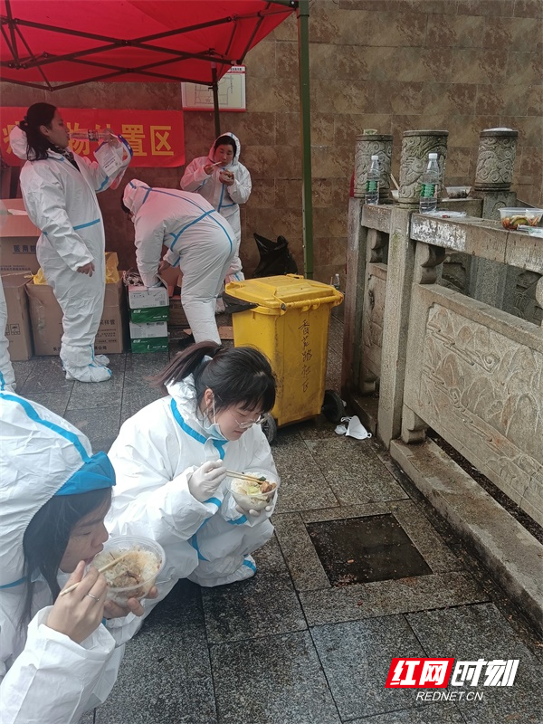 图六2月16日中午14点，在香花路社区恒利花园小区核酸检测采样点值守的工作人员好不容易抽空到路边吃了个盒饭。.jpg
