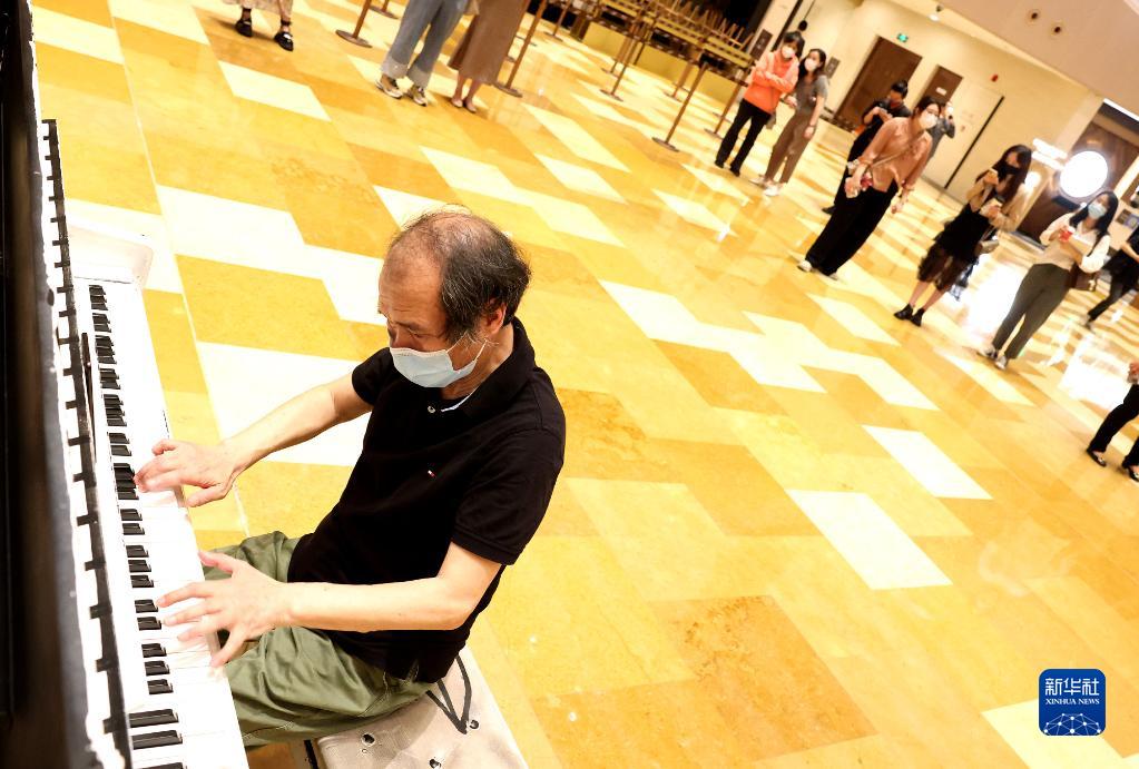 6月1日，74岁的上海市民黄为民在上海兴业太古汇商场弹奏钢琴。 新华社记者 陈飞 摄