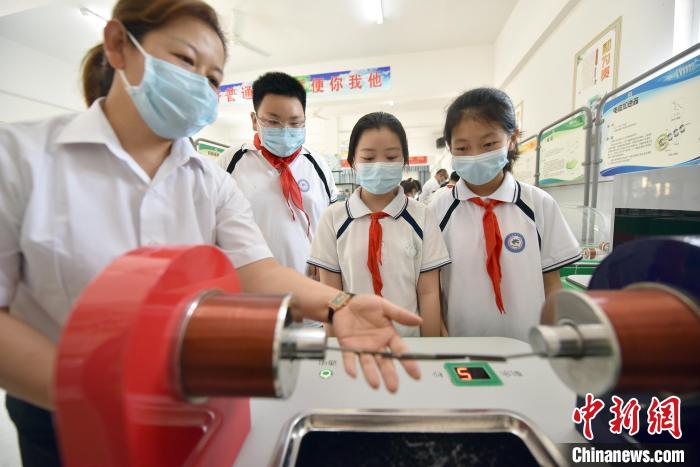 在文安县孟家务中心小学的流动科技馆，学生在体验“铁钉桥”项目。　高丹钰 摄
