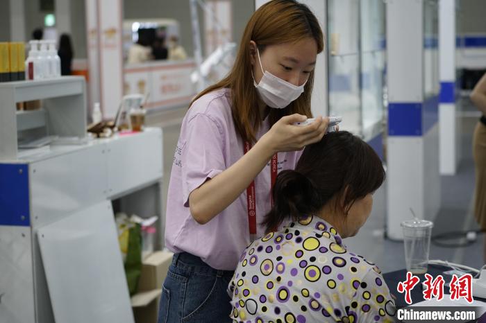 图为观众在博览会上体验头皮检测项目。　刘旭 摄