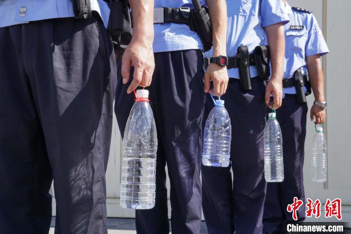 每位民警都提着大水瓶以便在巡逻时补水解暑。　王以照 摄