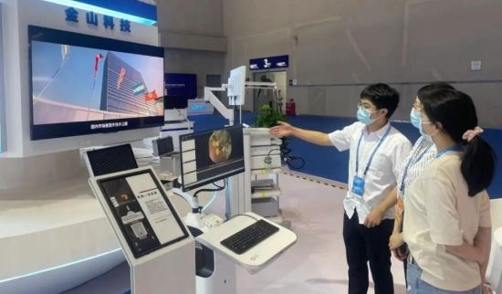 图为工作人员为参展观众介绍全自动导航胶囊内镜机器人工作原理。蒋林 摄