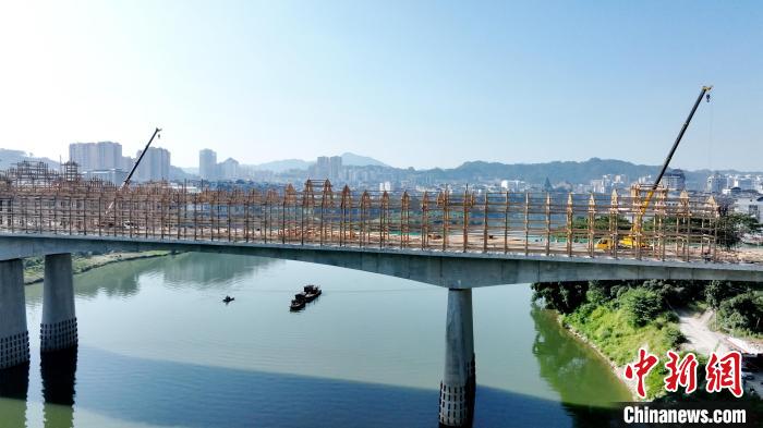 7月26日，在广西三江侗族自治县古宜镇正在建设中的宜阳风雨桥上，工匠正在施工。　吴练勋 摄
