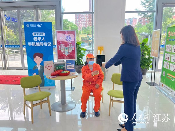 庐山路移动营业厅爱心休息站内，业务员为环卫工阿姨倒水。人民网 李子佩摄