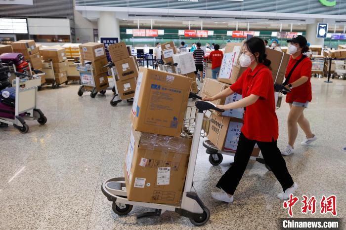 上海援琼医疗队医护人员推着行李在虹桥机场T2航站楼内行走。　殷立勤 摄
