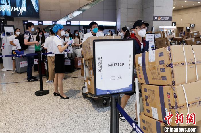 上海援琼医疗队医护人员推着行李在虹桥机场T2航站楼内行走。　殷立勤 摄