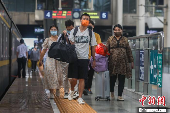图为江西南昌站，几位旅客携带行李从站台上走过。　刘力鑫 摄