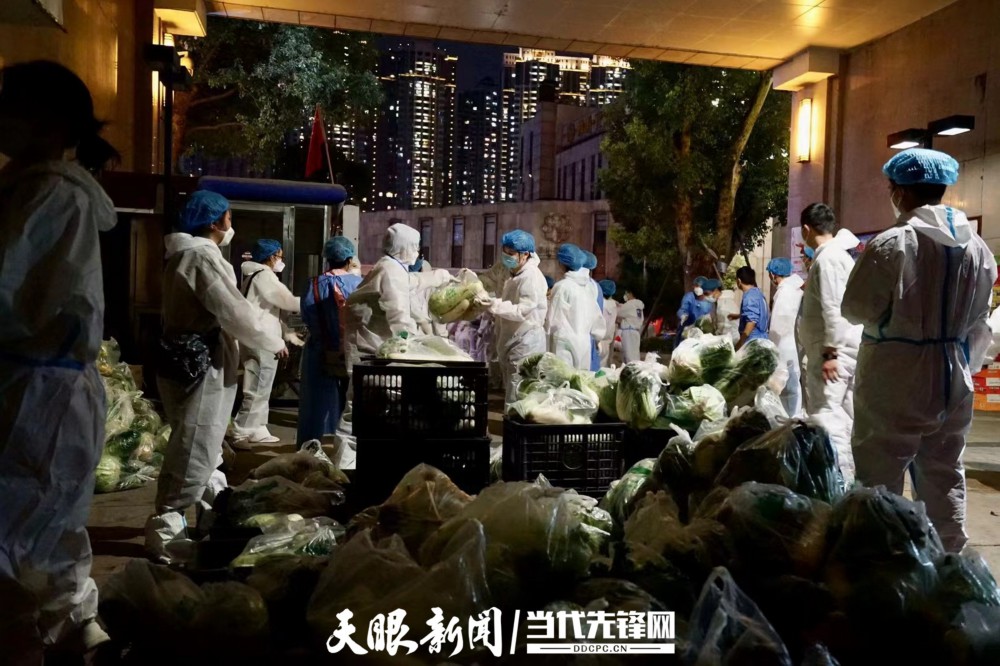 花果园街道办事处隆园社区的志愿者正接过蔬菜包，即将分到住户手中。（蔡雪 摄）.jpg