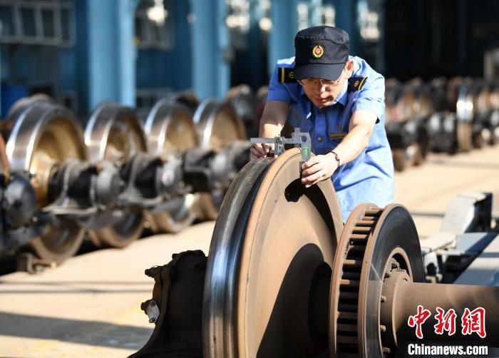 29日，在南昌客技站，客车检车员正在对轮对进行测量。　胡国林 摄