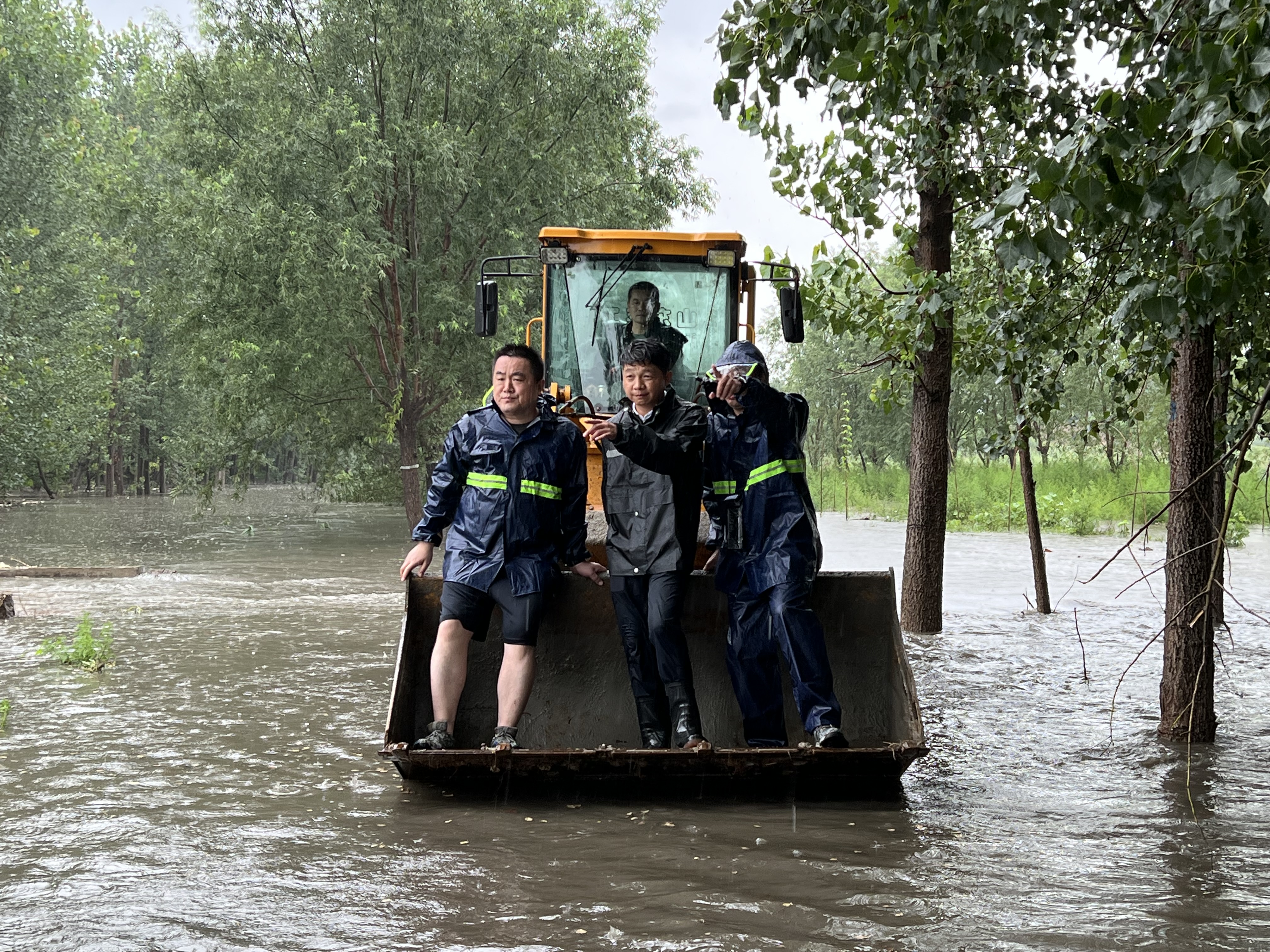 7月5日，可振虎（左一）乘坐工程车辆赶往羑河白营镇徐庄段漫堤现场处置险情.jpg